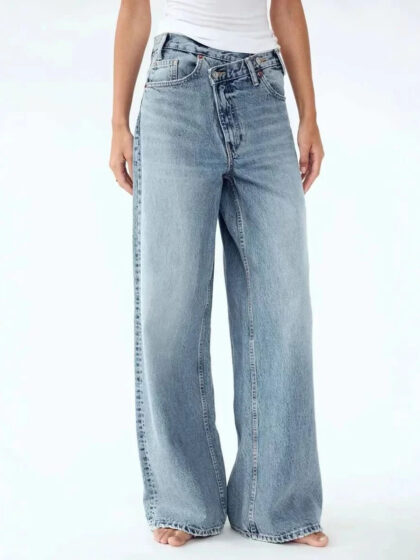 Wide-leg blue jeans on a person wearing a white top.